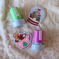 Load image into Gallery viewer, Two colorful stamps with Christmas-themed designs on a fluffy beige surface
