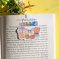 Book with a 'Summer' themed bookmark on a yellow background