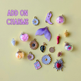 Load image into Gallery viewer, Collection of various charms on a yellow background with 'ADD ON CHARMS' text.
