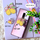 Phone case with lemon design, pop grip, dust plug, and stickers on a purple background.