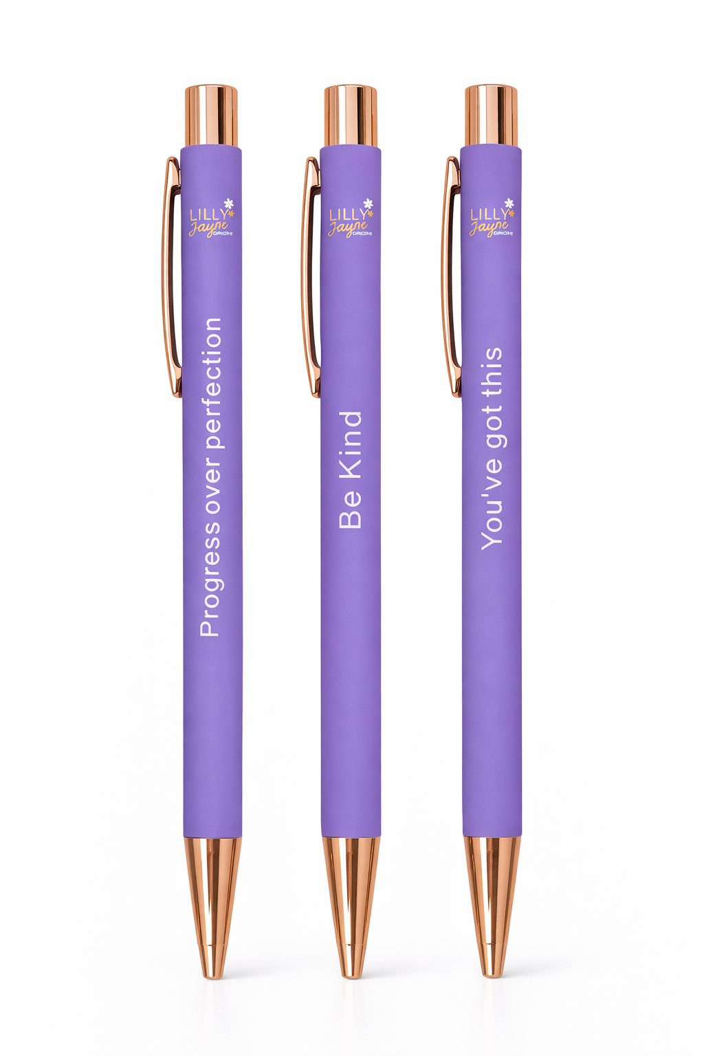 Three purple pens with rose gold accents and motivational text on a white background