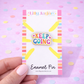 Enamel pin with 'Keep Going' text on a colorful card against a pink background