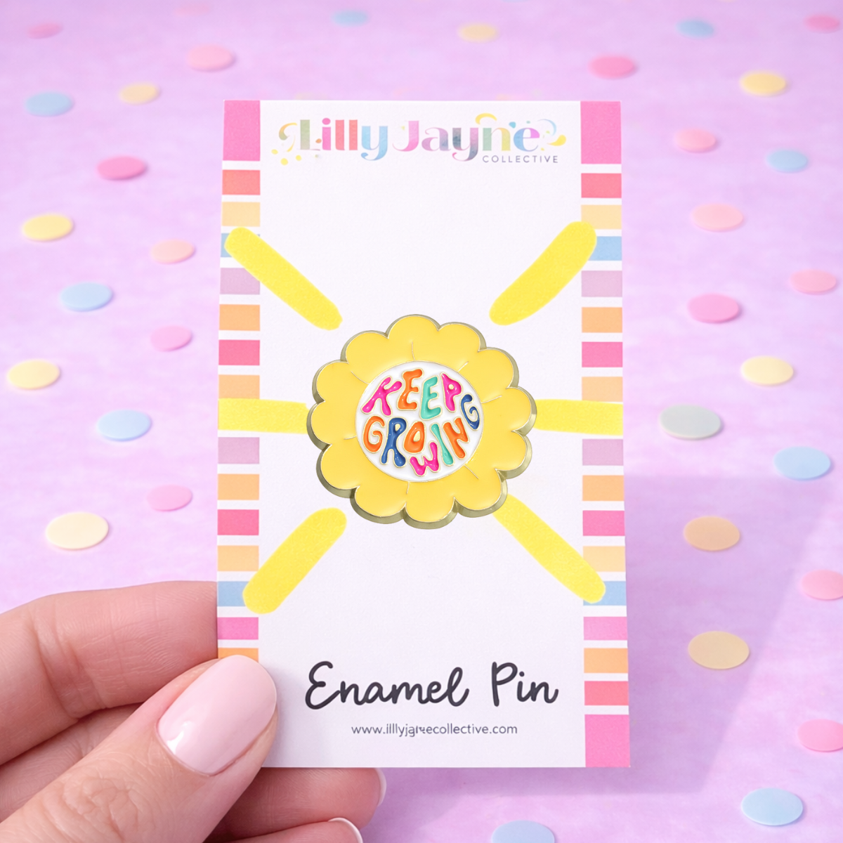 Enamel pin with 'Keep Growing' design on a card held against a polka dot background