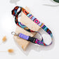 Colorful dog leash on a white surface with green leaves in the background