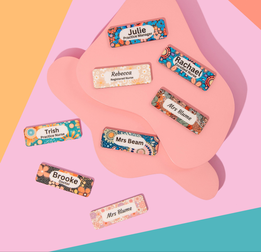 Colorful name badges with floral designs on a pink background