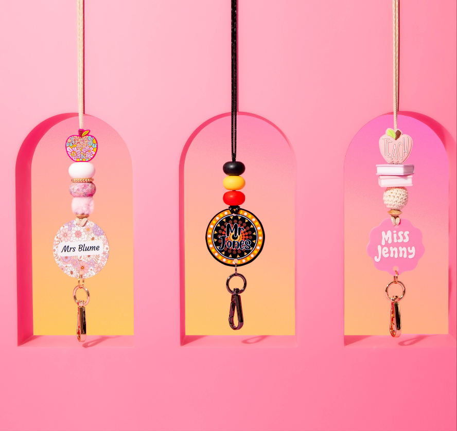 Three decorative keychains with names on a pink background