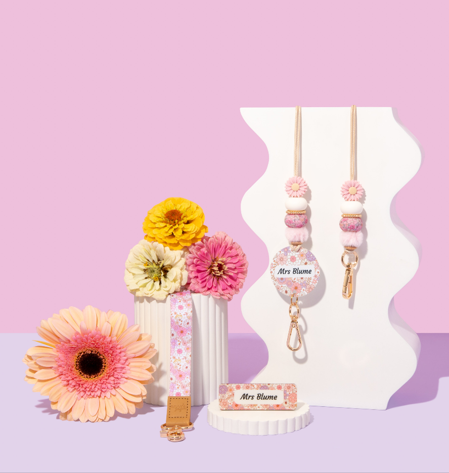 Decorative items with flowers and a keychain on a pink and purple gradient background