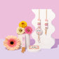Decorative items with floral designs on a pink and purple gradient background