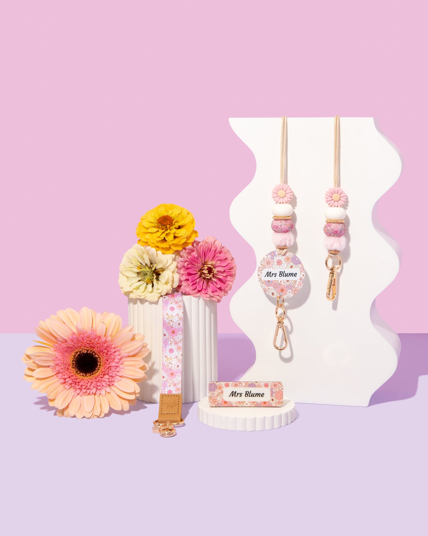 Decorative items with floral designs on a pink and purple gradient background