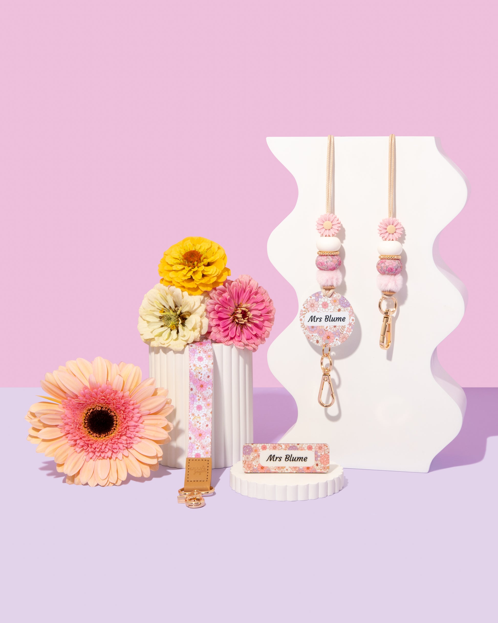 Decorative items with floral designs on a pink and purple gradient background