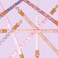 Set of colorful bag straps with floral and geometric patterns on a light purple background