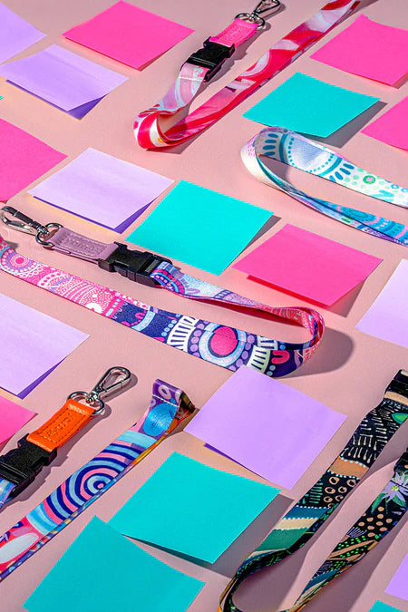 Colorful lanyards and sticky notes on a pink background