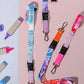 Colorful lanyards with keychains on a pink background