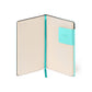 Open notebook with a turquoise strap and corner label on a white background