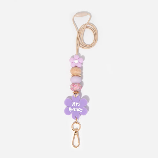 Lanyard with purple flower silicone focal beads and a matching purple flower personalised name disc. With wooden Bead and pretty floral and purple silicone beads.