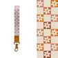 retro orange checker floral pattern Wristlet, laid on pastel notebooks with floral accents – Lilly Jayne Collective.