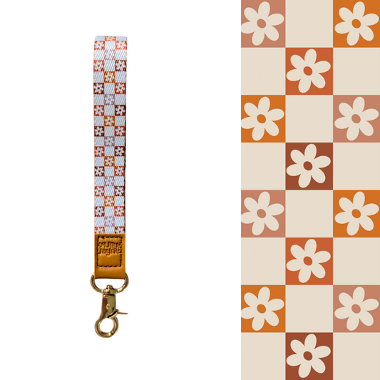 retro orange checker floral pattern Wristlet, laid on pastel notebooks with floral accents – Lilly Jayne Collective.