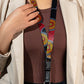 Person wearing a colorful beaded lanyard with a red background