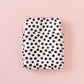 Polka dot patterned pouch on a pink background