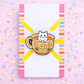 Enamel pin of a cat in a teacup with a colorful background