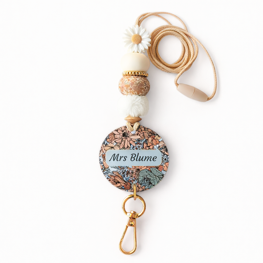 Decorative lanyard with floral design and 'Mrs Blume' text on a white background