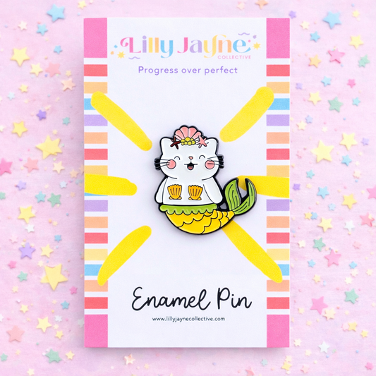 Enamel pin with a cat mermaid design on a colorful background with 'Lilly Jayne' branding.