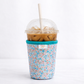 Floral-patterned cup sleeve with a plastic cup containing iced coffee on a white background