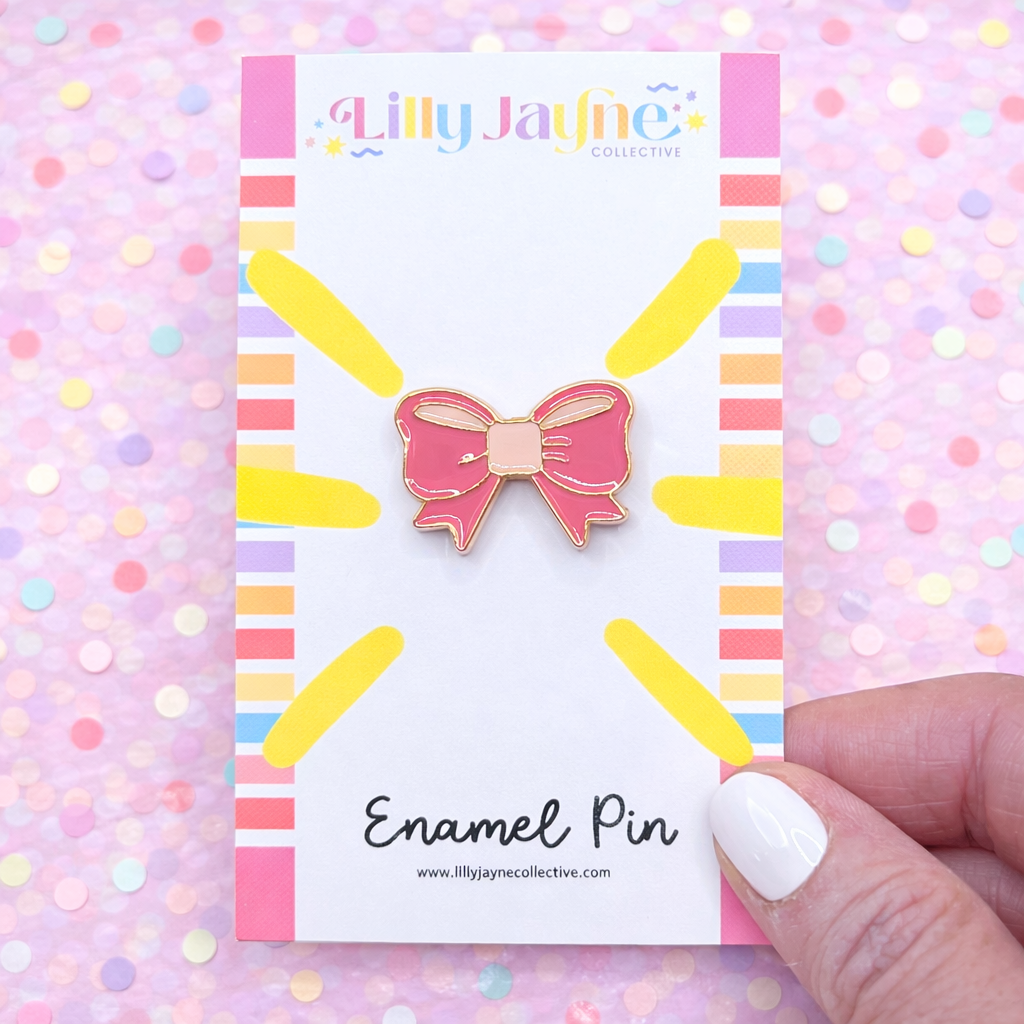 Pink bow enamel pin on a colorful card with 'Lilly Jayne Collective' branding.