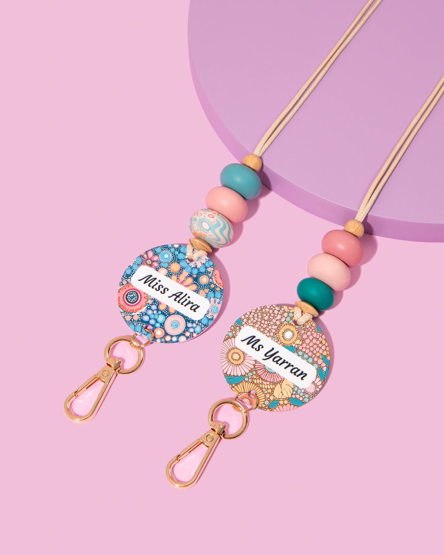 Colorful name badge holders with beads on a pink background