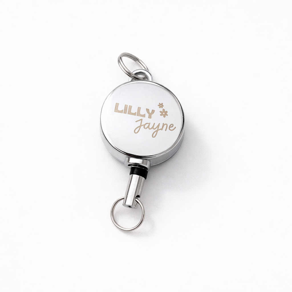 Silver retractable badge holder with 'LILLY JAYNE' engraving on a white background