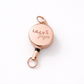 Rose gold retractable badge holder with 'LILLY Jayne' engraving on a white background