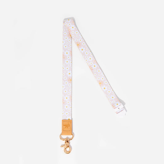A fabric lanyard featuring a pattern with daisy flowers and a faux leather trim, secured with a strong silver clasp.