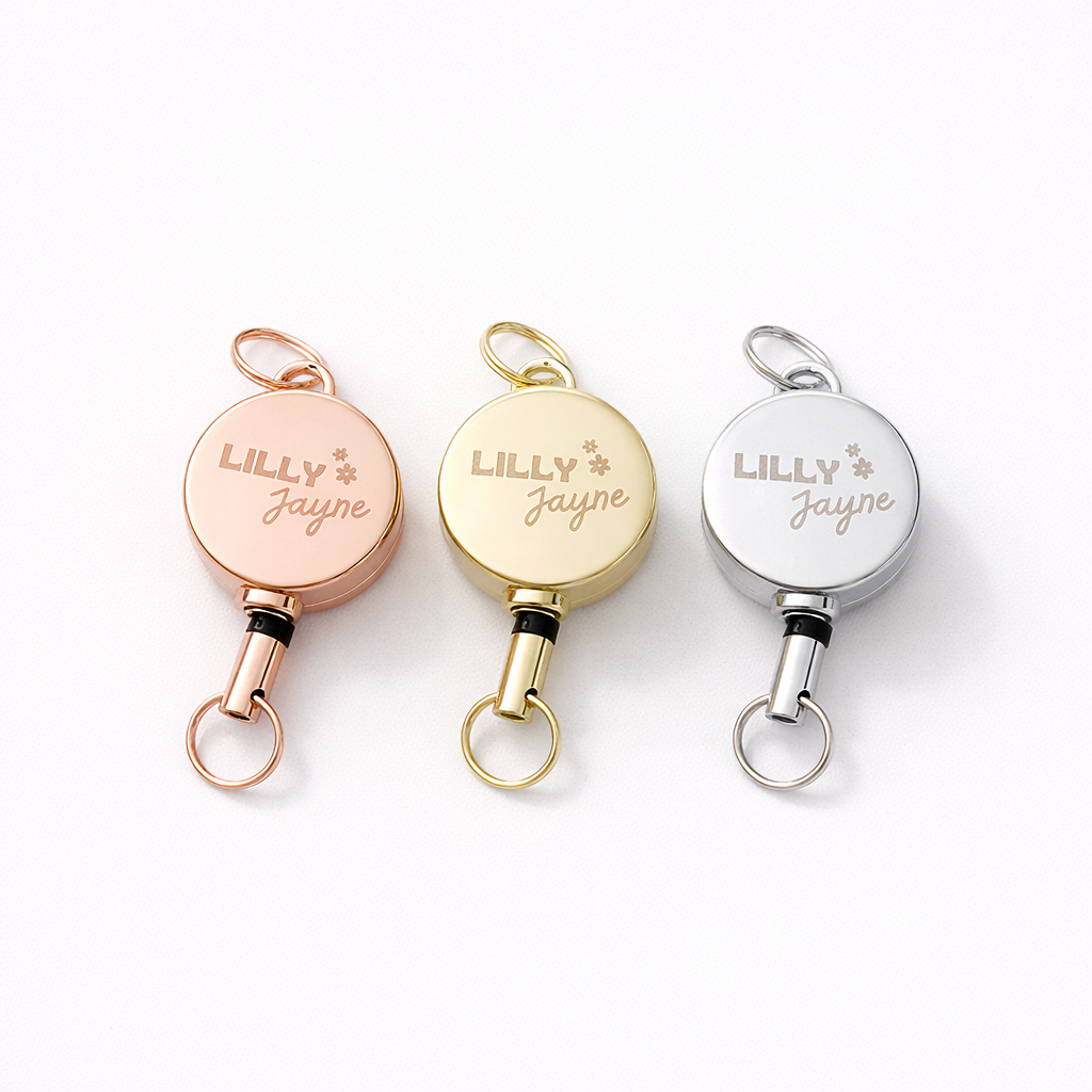 Three retractable keychains with 'LILLY JAYNE' engraving on a white background