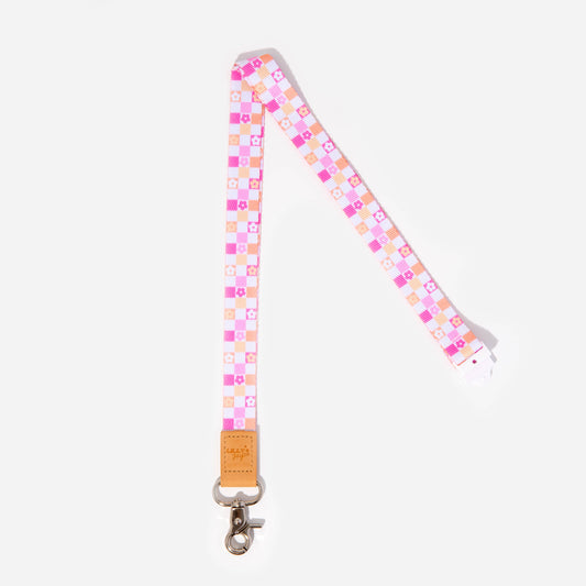 A colorful geometric patterned lanyard with a faux leather trim, silver clasp, and breakaway safety clasp.