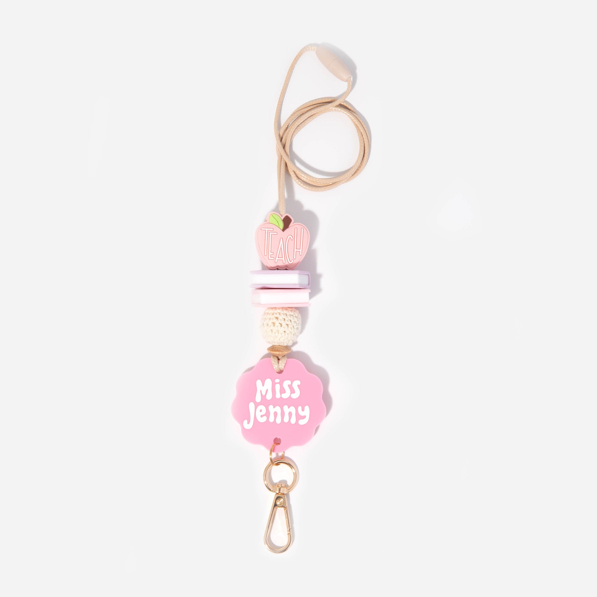 A pink personalized teacher lanyard with a name tag and floral pattern, featuring a gold-colored breakaway clasp and a metal clip.