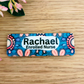 A personalized name badge with a colorful patterned background featuring the name Rachael Enrolled Nurse.