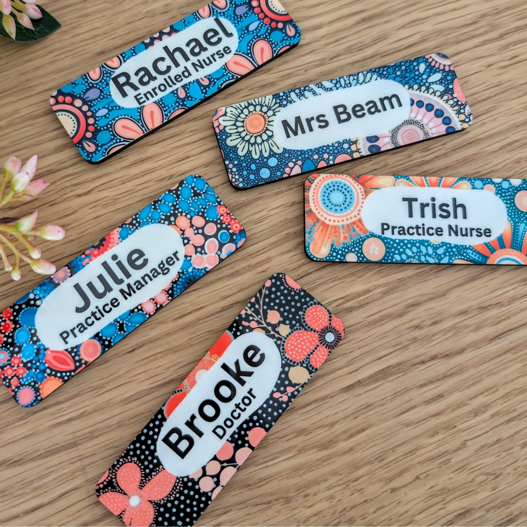 Colorful name tags with floral designs on a wooden surface