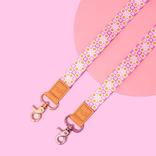 Pink strap with floral pattern and gold hardware on a pink background