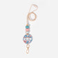 A personalised lanyard with a circular badge featuring the name 'Mrs. Smith' in a floral pattern, with a pink and gold color scheme, attached to a breakaway safety clasp and a metal clip.