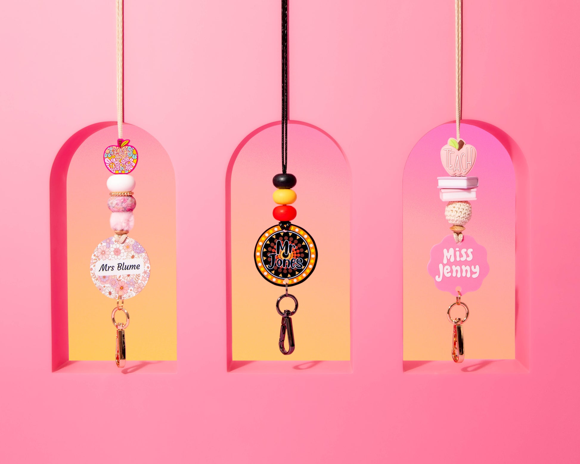 Decorative keychains hanging against a pink background